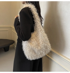 Détail d'un sac à bandoulière en fausse fourrure blanche porté par un mannequin