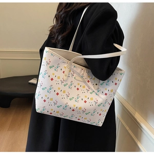 Détail d'un grand sac cabas blanc à fleurs en similicuir avec mannequin en décor moderne