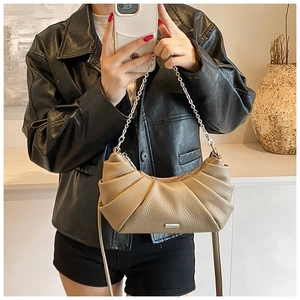 Detailed close-up of khaki pleated half-moon bag with metallic chain and leather strap