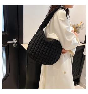 Close-up of black quilted cloud bag showing the puffy fabric and 3D square texture