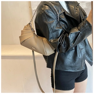 Detail of khaki pleated dumpling bag with silver chain and leather strap on model