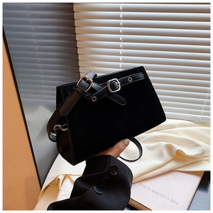Close-up of black retro shoulder bag showing matte texture and silver metal buckles