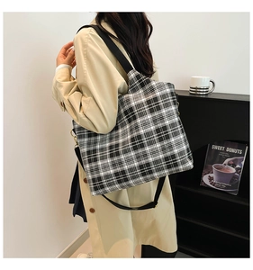 Detail of checkered canvas tote bag with black wide strap and large storage capacity