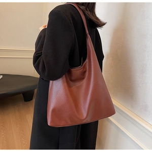 Detail of a large brown tote bag with premium lychee texture leather for daily commuting