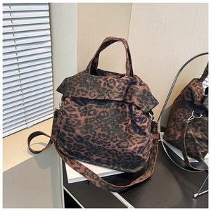 Leopard print canvas tote bag with adjustable shoulder strap on minimalist wooden desk