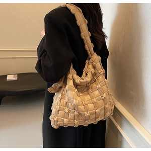 Gros plan d'un sac cabas kaki avec texture matelassée 3D et grande capacité de rangement