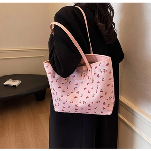 Vue détaillée du sac cabas en cuir PU rose avec motifs cerises porté à l'épaule