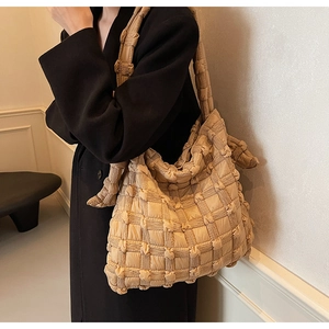Détail du sac cabas beige en tissu gaufré montrant l'artisanat plissé matelassé