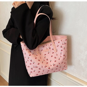 Détail du sac cabas en cuir PU rose avec motif cerise et longues anses sur l'épaule