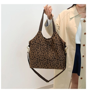 Detail of leopard print tote bag featuring golden hardware and adjustable brown shoulder strap