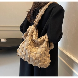 Détail du sac fourre-tout beige matelassé avec texture bulles 3D et large bandoulière