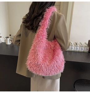 Détail d'un sac à bandoulière en fausse fourrure rose vif porté avec un blazer gris