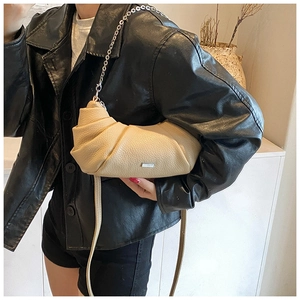Detail of beige croissant bag with lychee texture, silver chain and metal logo