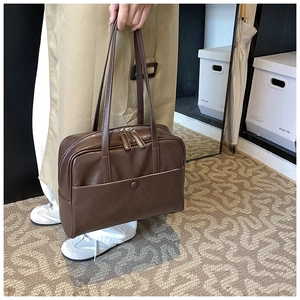 Close-up of vintage dark brown PU leather Boston bag with double zippers and outer pocket