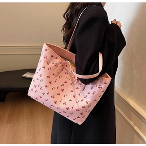 Vue latérale du sac fourre-tout rose avec motif cerise porté par un mannequin