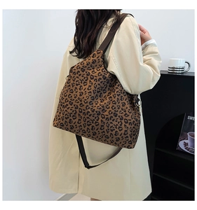 Detail of hobo shoulder bag featuring leopard print fabric and wide textile strap