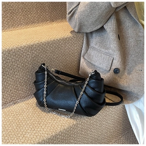 Detail of black lychee texture PU leather shoulder bag with chic pleated design