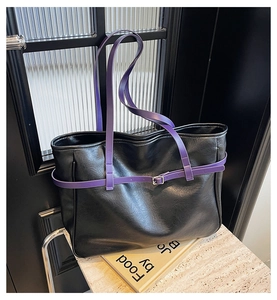 Close-up of black PU leather tote bag featuring striking purple handles and metal buckle