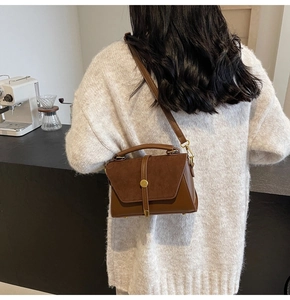 Detailed close-up showing the suede and smooth leather texture of the brown shoulder bag