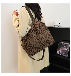 Detail of leopard print canvas bag with adjustable shoulder strap and gold hardware buckle