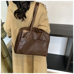 Detail of a deep brown PU leather tote bag with large front pocket and double handles