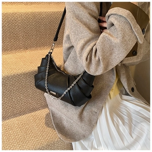 Detail of black pleated PU crescent moon shoulder bag with elegant silver chain strap