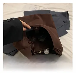 Détail du grand sac cabas en daim marron avec fermeture magnétique et espace intérieur