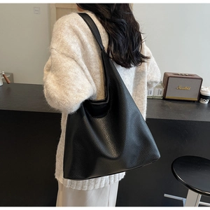 Chic black litchi grain PU leather hobo bag styled on shoulder in a cafe setting
