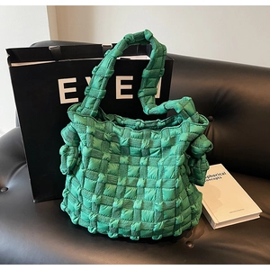 Sac fourre-tout tissé matelassé vert vif tendance sur un canapé noir pour le style d'automne