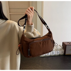 Dettaglio della borsa a mezzaluna in nylon marrone scuro con tasche funzionali multi-zip