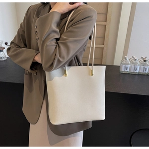 Detail of creamy white lychee grain PU leather tote bag with elegant gold hardware