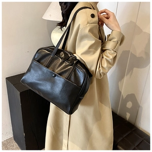 Detail showing high-quality black PU leather texture and stylish front buckle on the handbag