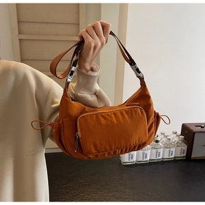 Dettaglio della borsa a mezzaluna in nylon caramello con cerniera e coulisse regolabile
