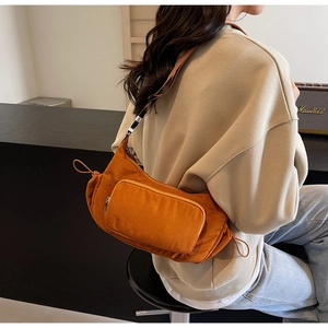 Dettaglio borsa a tracolla in nylon arancione bruciato con coulisse laterale e tasca a zip
