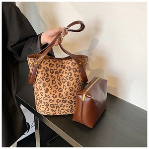 Détail du sac seau à imprimé léopard et pochette assortie en cuir marron avec rivets