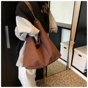 Détail du grand sac cabas marron mat avec œillets métalliques et bandoulière réglable