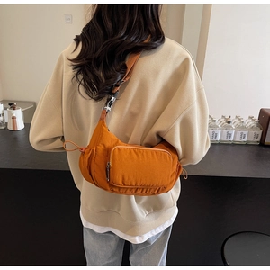 Dettaglio della borsa a mezzaluna in nylon arancione con tracolla e tasca a zip