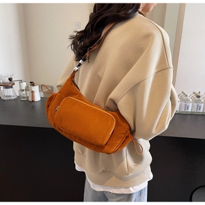 Dettaglio borsa a mezzaluna in nylon caramello con coulisse laterali e tasca con cerniera