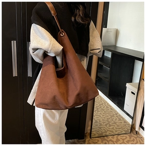 Sac fourre-tout marron mat sur modèle montrant la grande capacité et le style rétro