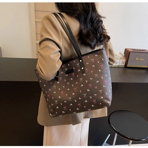 Détail du grand sac cabas avec imprimé floral à nœuds roses et fines bretelles noires