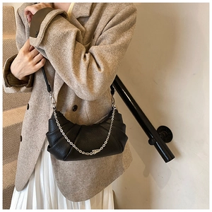 Detail of black pleated cloud bag showing lychee texture, silver chain and zipper closure