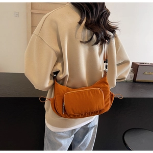 Dettaglio della borsa a tracolla in nylon giallo zenzero con coulisse su una modella