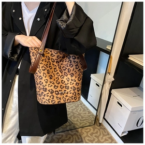 Vue détaillée du sac cabas léopard avec lanières en cuir et détails de rivets