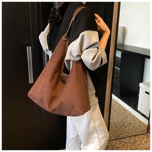Détail du sac hobo en daim marron mat avec fine bandoulière et grande capacité interne
