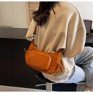 Dettaglio borsa a tracolla in nylon marrone arancio con cinghia larga e fibbia