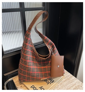 Detail of vintage houndstooth tote bag with brown leather trim and mini pouch accessory