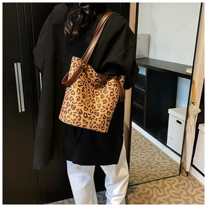 Détail d'un grand sac cabas à imprimé léopard avec des anses en cuir marron tendance