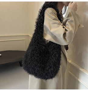 Détail d'un sac à épaule en fausse fourrure noire douce avec une texture très pelucheuse