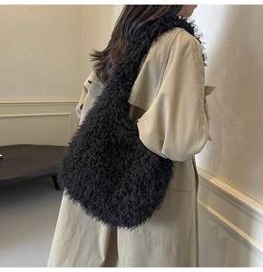 Mannequin portant un grand sac hobo noir en fausse fourrure avec un trench-coat beige chic