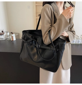 Detailed view of black textured PU leather tote bag with stylish silver metal buckle